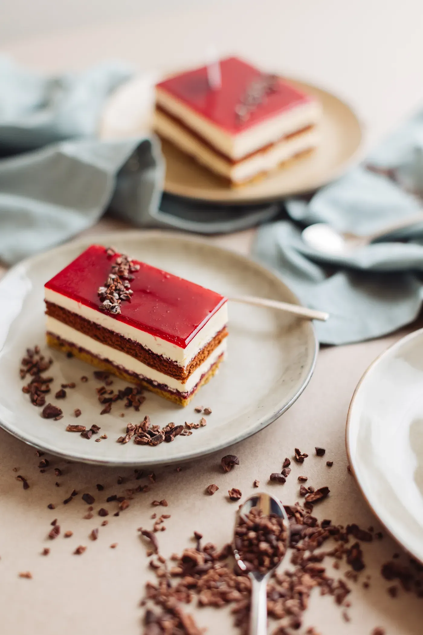Semifreddo Loren con glassa rossa e decorazione al cacao su piatto chiaro.